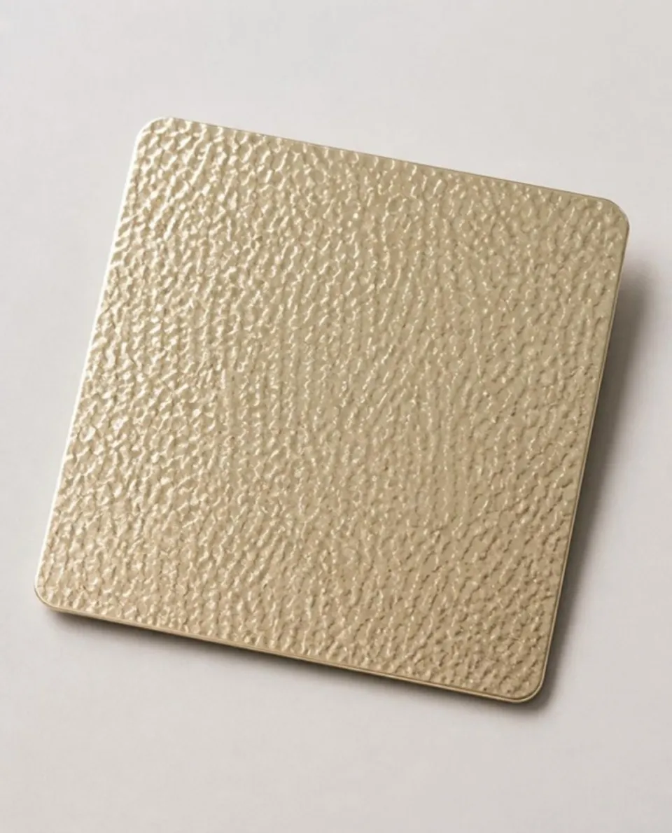 Champagne gold embossed stainless steel sheet sample, raised embossed texture (AI studio visual)