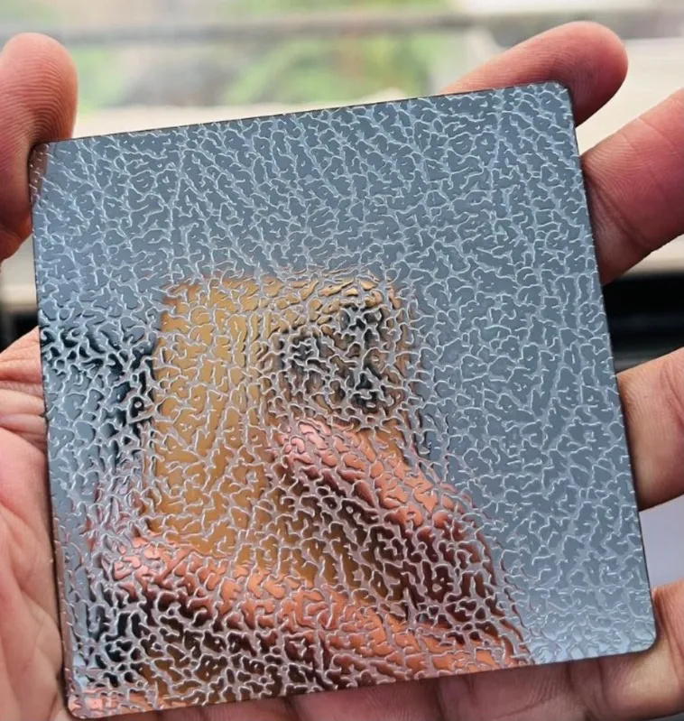 Embossed stainless steel sample with a raised pebble texture